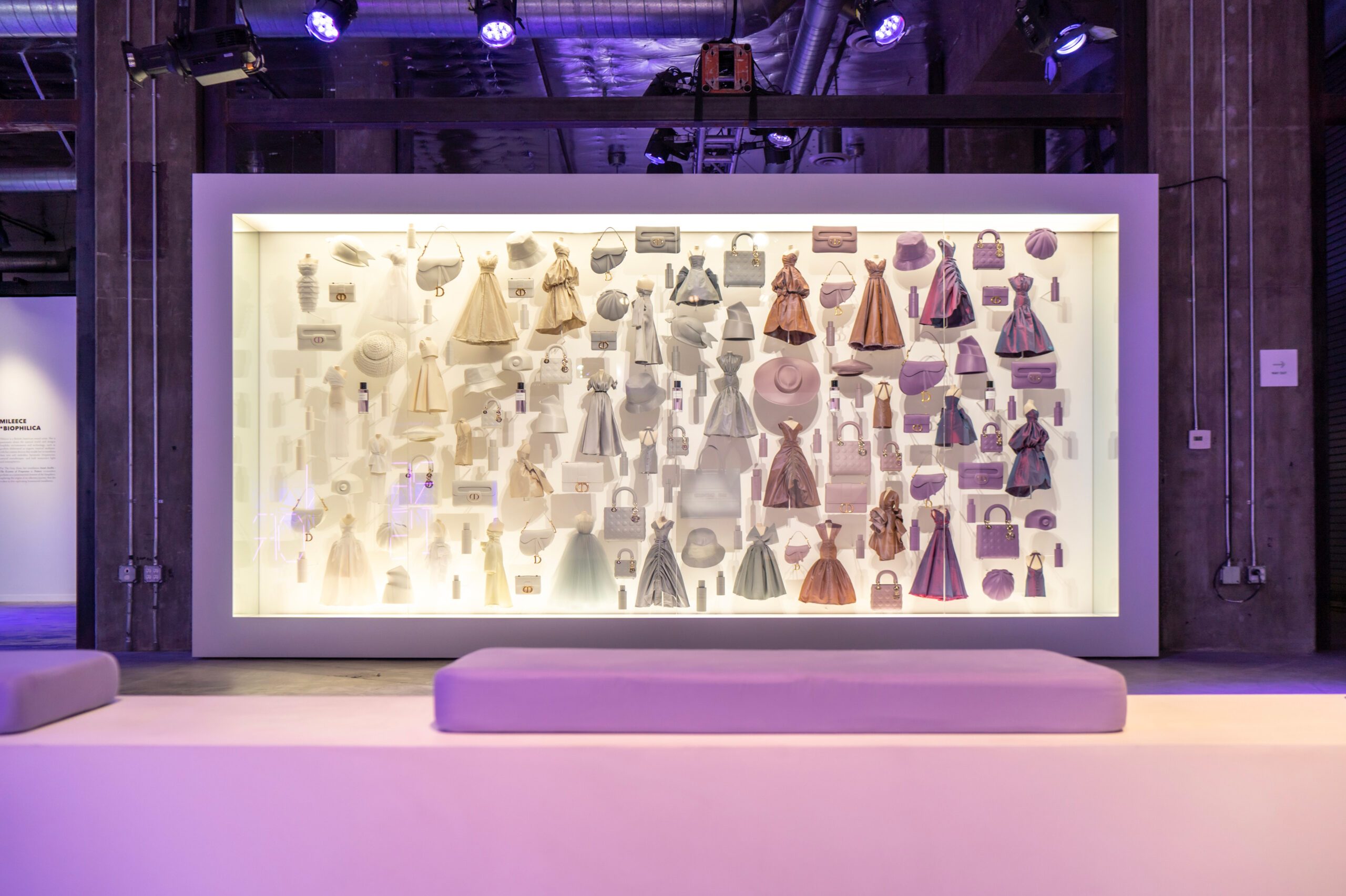 Dior's dresses and bags displayed on a fashion wall at the The Grey Zone luxury event, created by Golden Mama.
