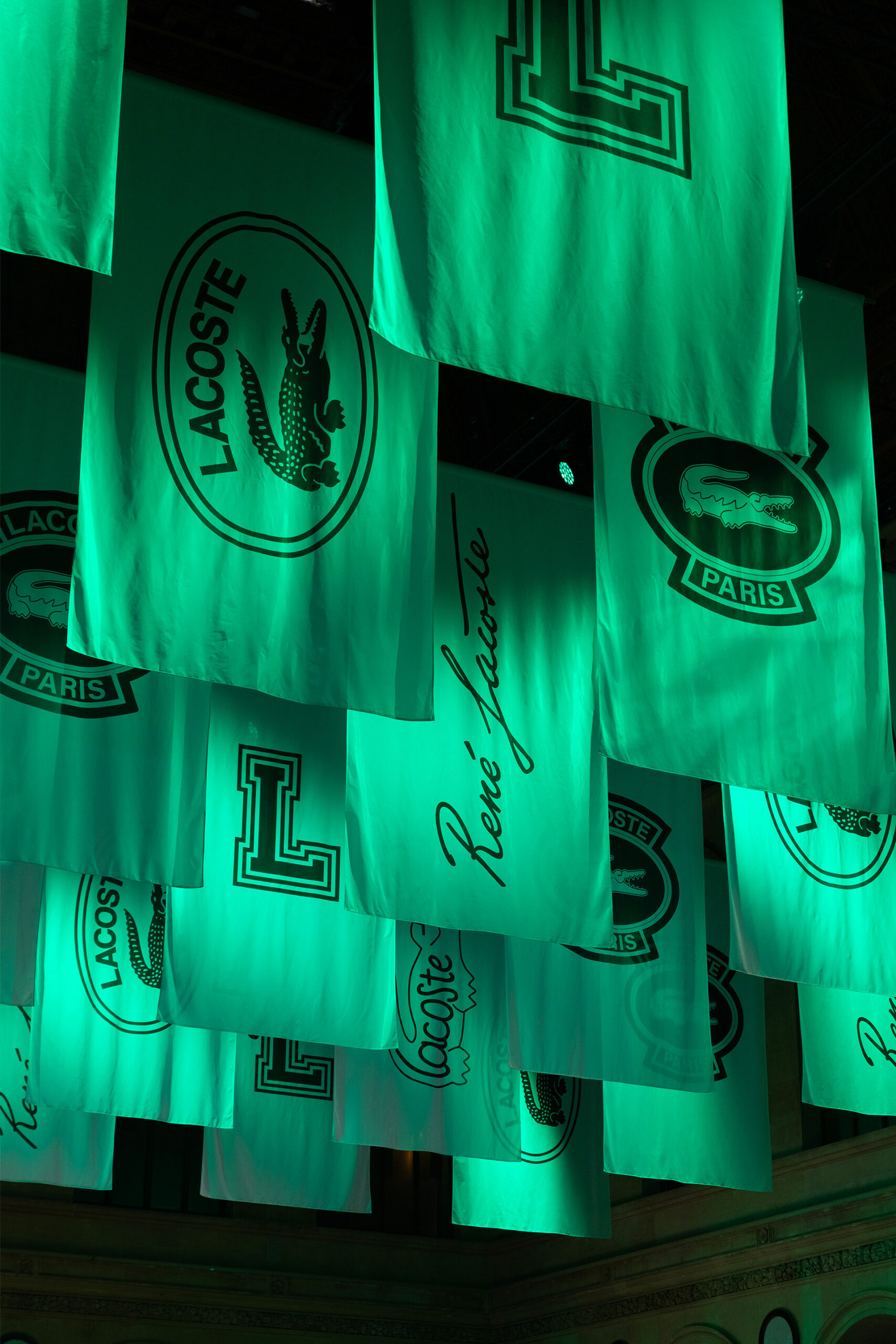 Top-hung logo banners of René Lacoste and the crocodile scenographed by Golden Mama